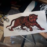 Sabre Tooth Tiger Red Orange Screenprint Back Patch on table with objects