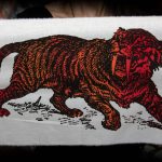 Sabre Tooth Tiger Red Orange Screenprint Back Patch held by hands